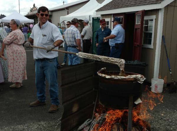 Cooking apple butter outside over a fire.