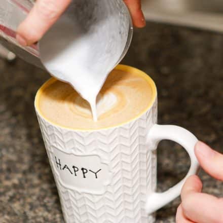 Pouring milk into latte.