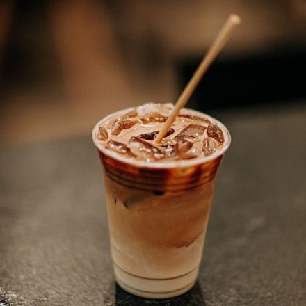 Iced coffee with a straw.